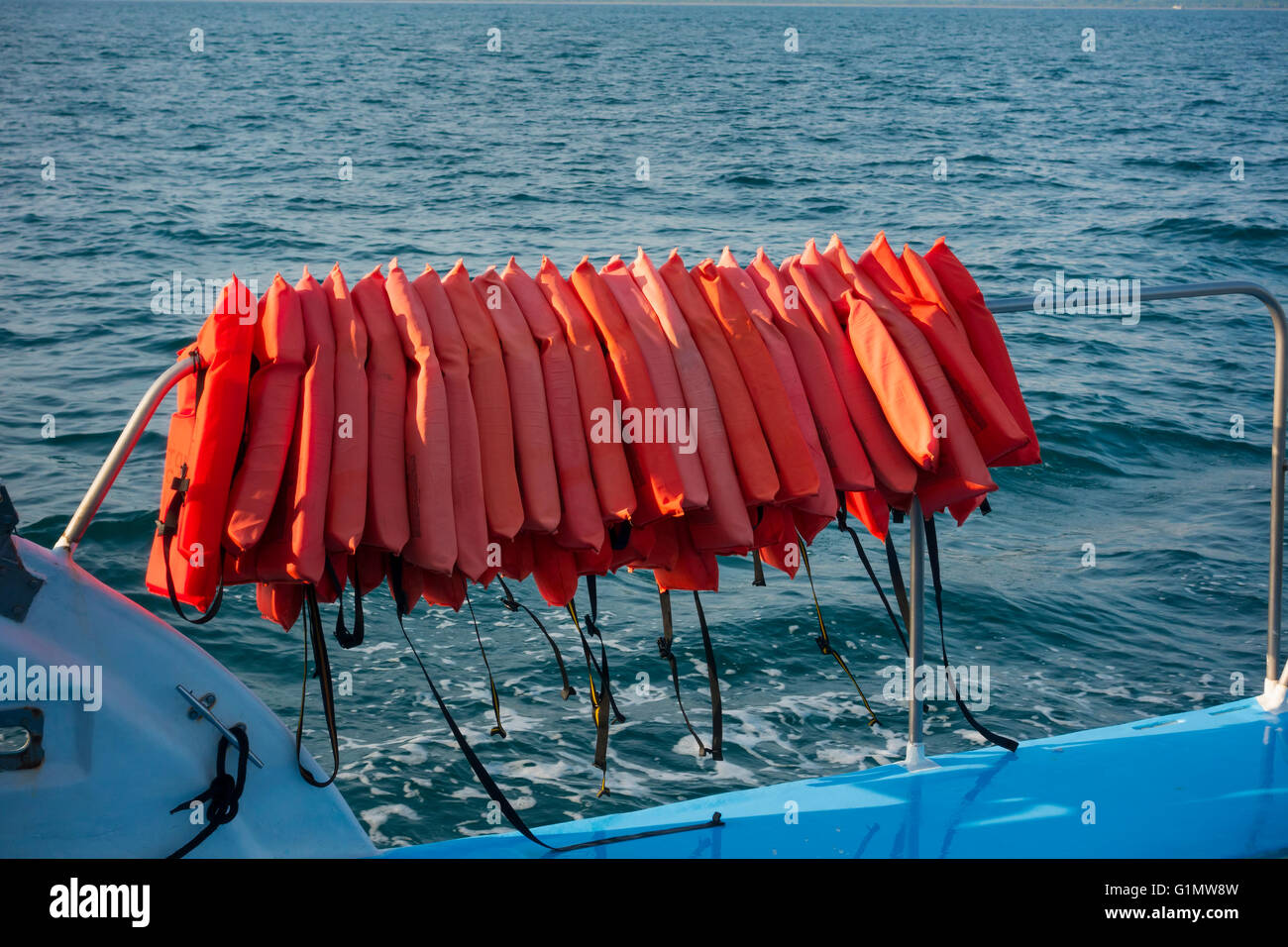 Life jackets hanging on the railing of a boat. Quepos, Costa Rica. Stock Photo