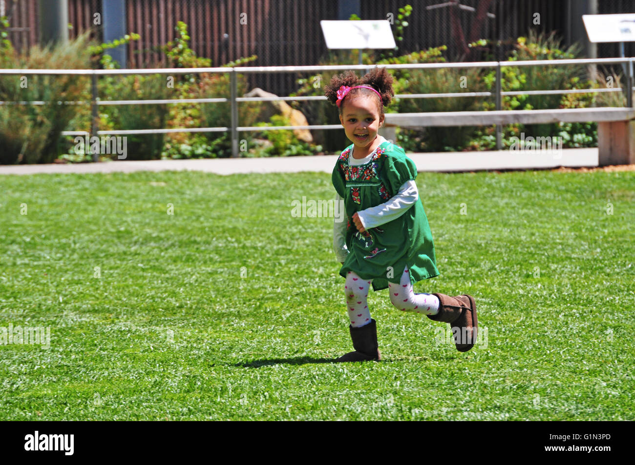 San Francisco, Usa: a baby girl running in the lawn of the California Academy of Sciences, famous research institute and natural history museum Stock Photo