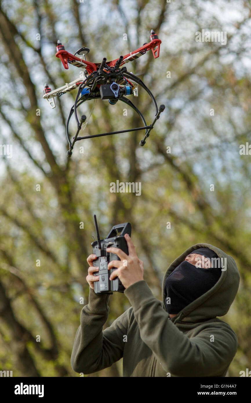 Man in mask operating a drone with remote control. Stock Photo