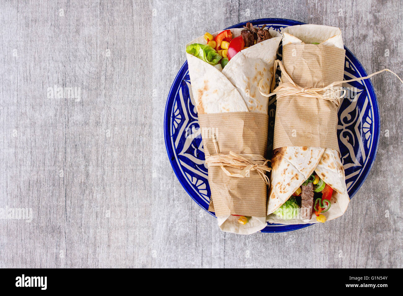 Mexican style dinner. Two papered tortillas burrito with beef and