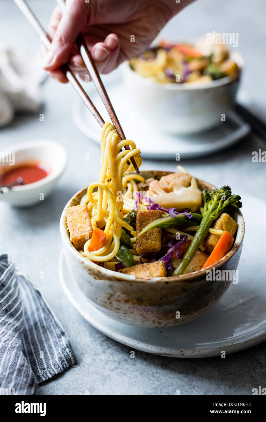 Curried noodles with crispy tofu & winter vegetables, gluten-free and vegan. Stock Photo