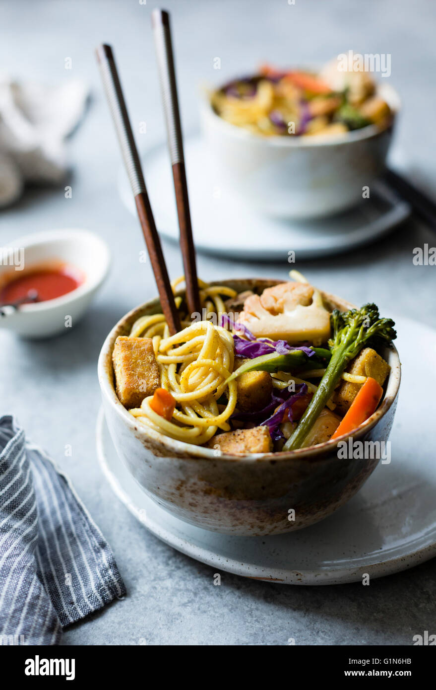 Curried noodles with crispy tofu & winter vegetables, gluten-free and vegan. Stock Photo