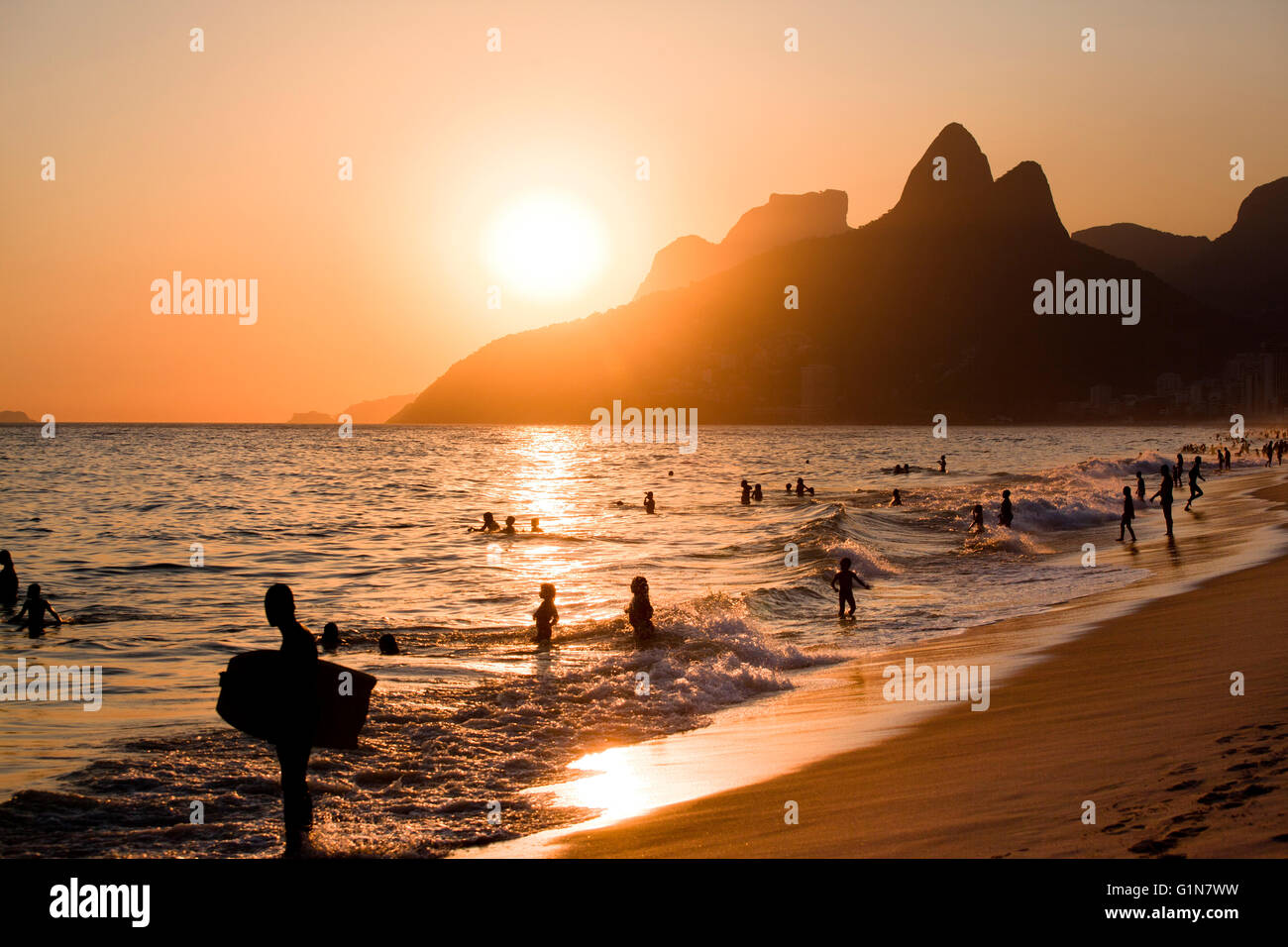 Ipanema beach at sunset, Morro Dois Irmãos ( Dois Irmaos Mountain or Two Brothers Mountain ) and Pedra da Gavea in background, Rio de Janeiro, Brazil. Stock Photo