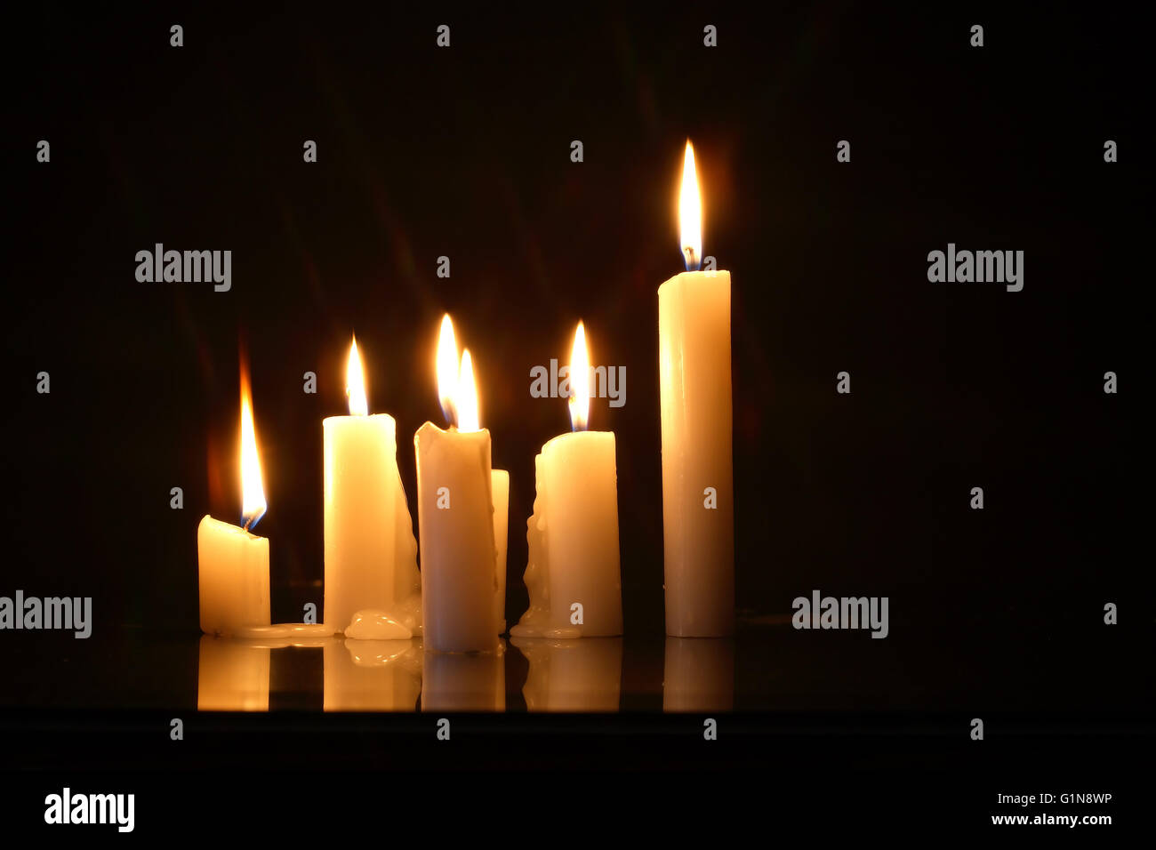 Few lighting candles in a row on dark background Stock Photo - Alamy