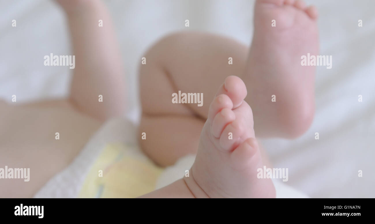Focus on babys feet on a bed Stock Photo