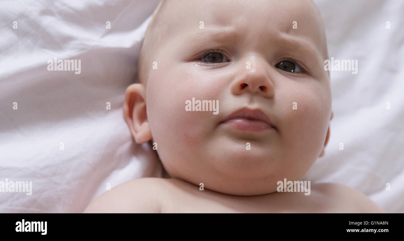 Portrait of baby lying on bed Stock Photo