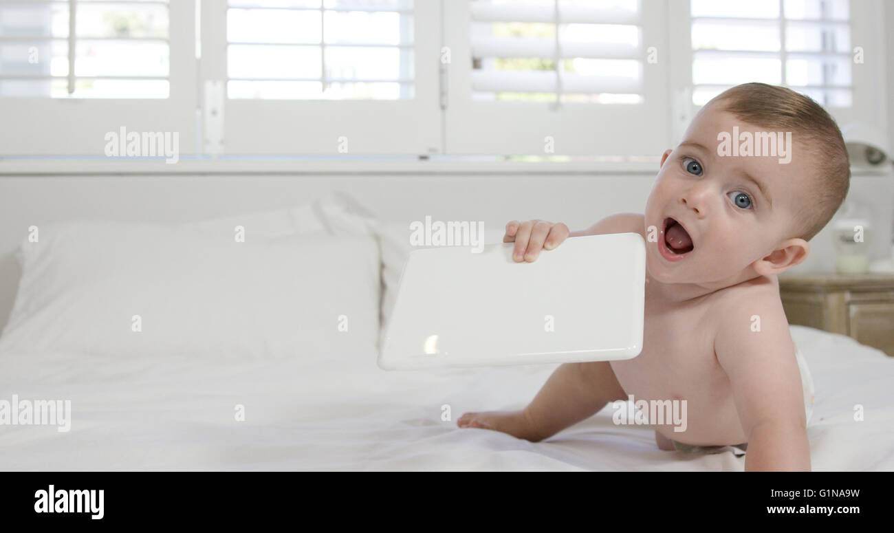 Baby boy chewing his tablet Stock Photo Alamy