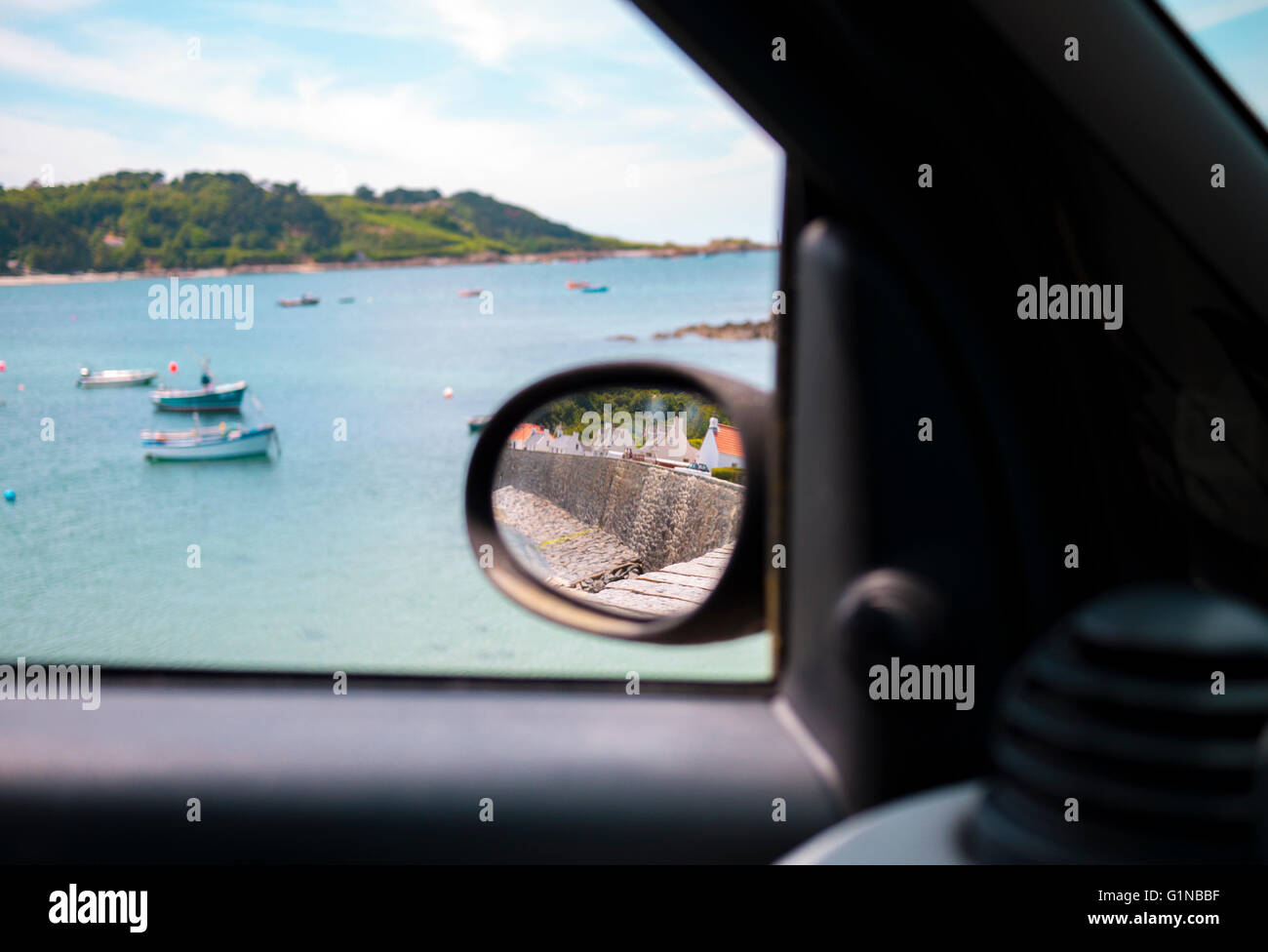 Unique view out a car window of a picturesque beach with fishing boats ...
