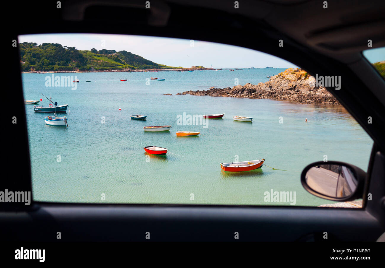 Unique view out a car window of a picturesque beach with fishing boats in Guernsey, Channel Island. Stock Photo