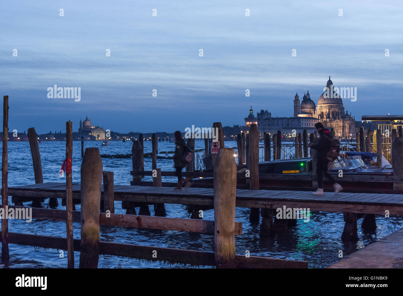 Basilica Santa Maria della Salute and Chiesa di  at night seen from Riva degli Schiavoni vaporetto stop Stock Photo