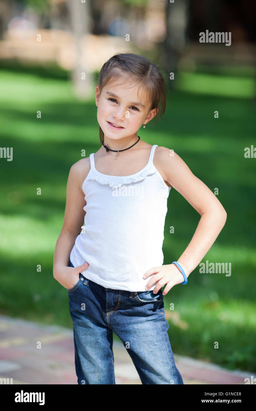Happy girl standing on the lawn in the park Stock Photo