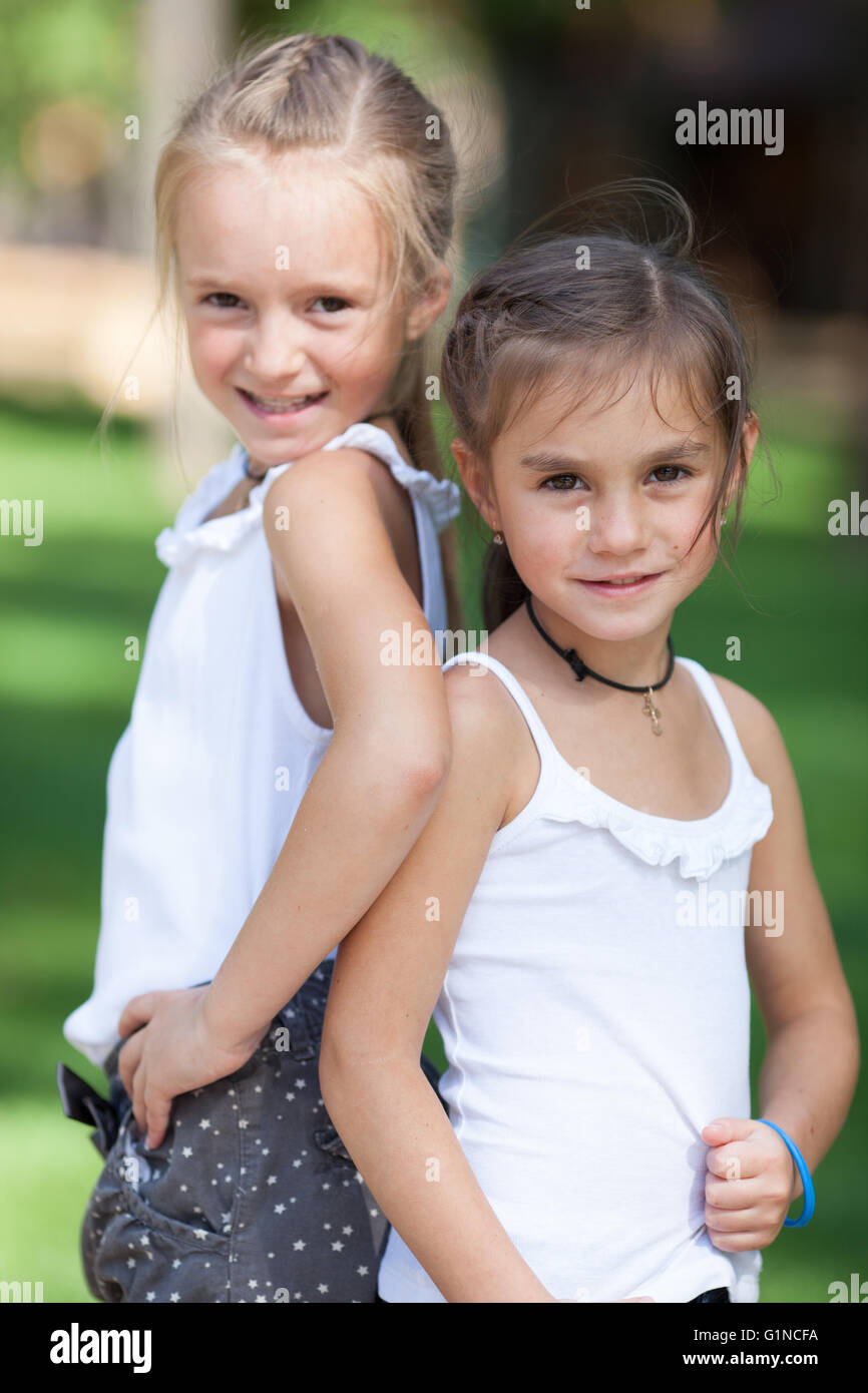 Wonderful happy girls standing on the lawn. Stock Photo