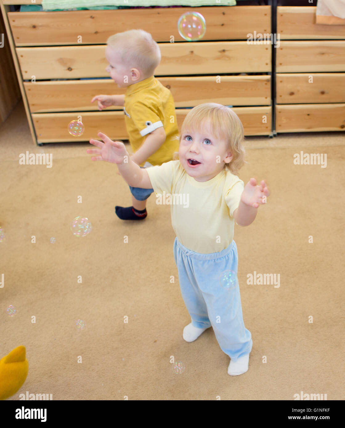 Children playing with soap bubbles in day care centre Stock Photo