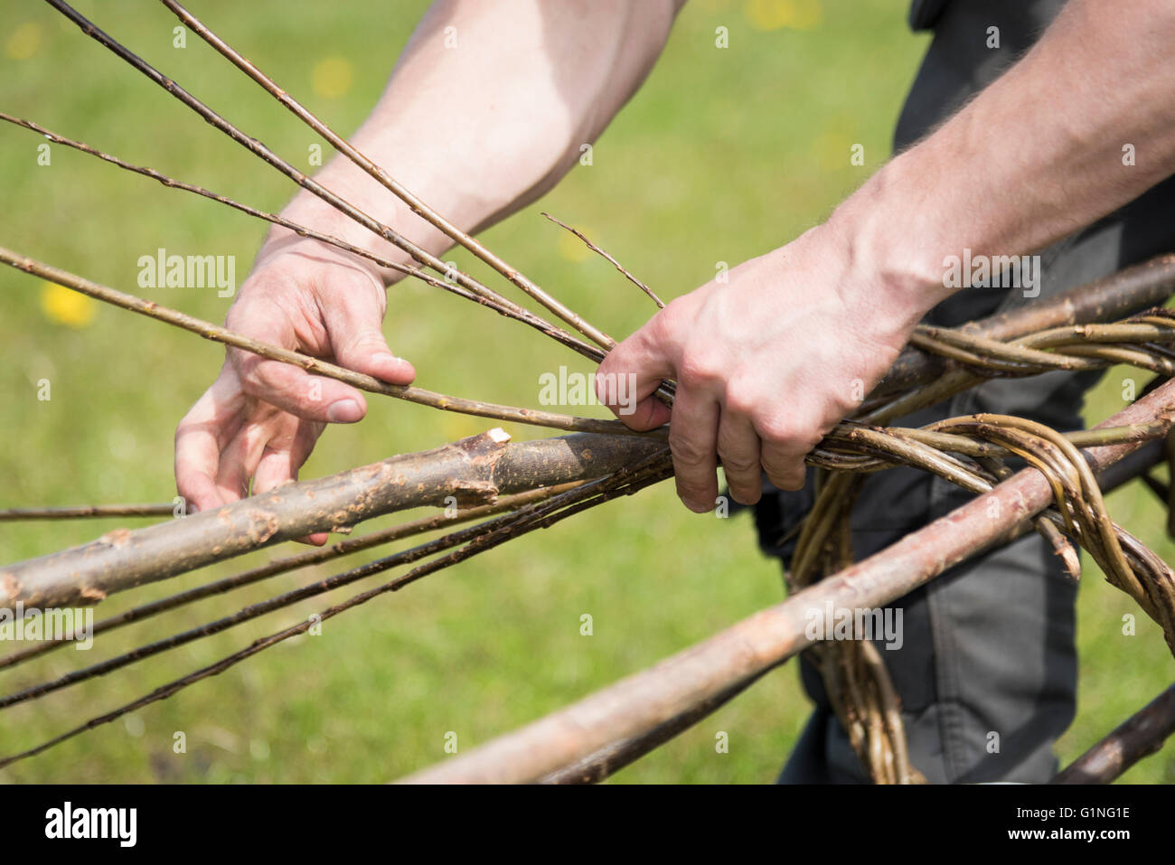 A man making willow plant supports at a craft fair in the UK Stock Photo