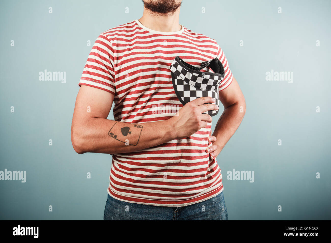 A young man is wearing a striped shirt and a checkered cap Stock Photo