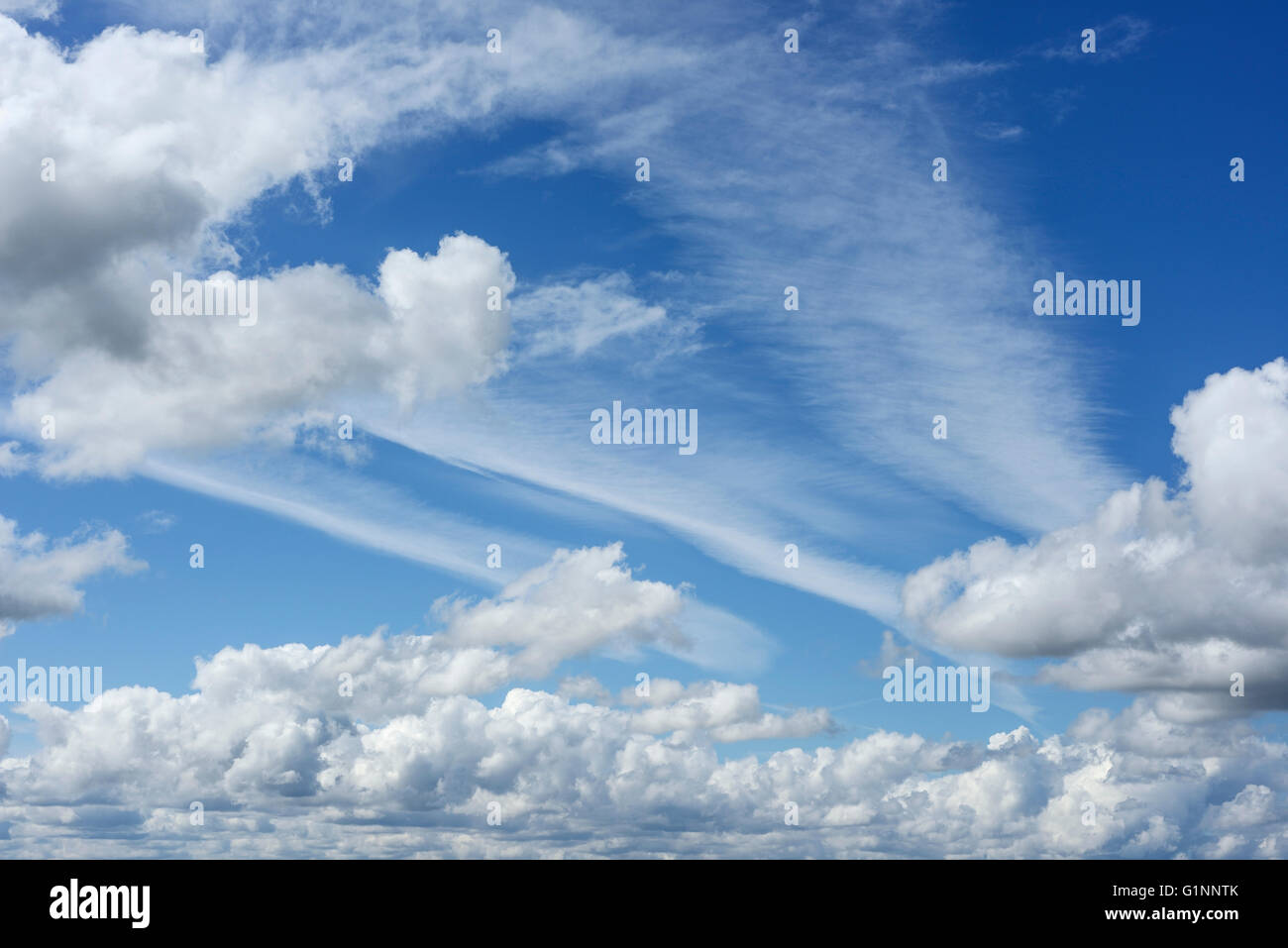 Summer cloud formations with blue sky and vapour trails Stock Photo