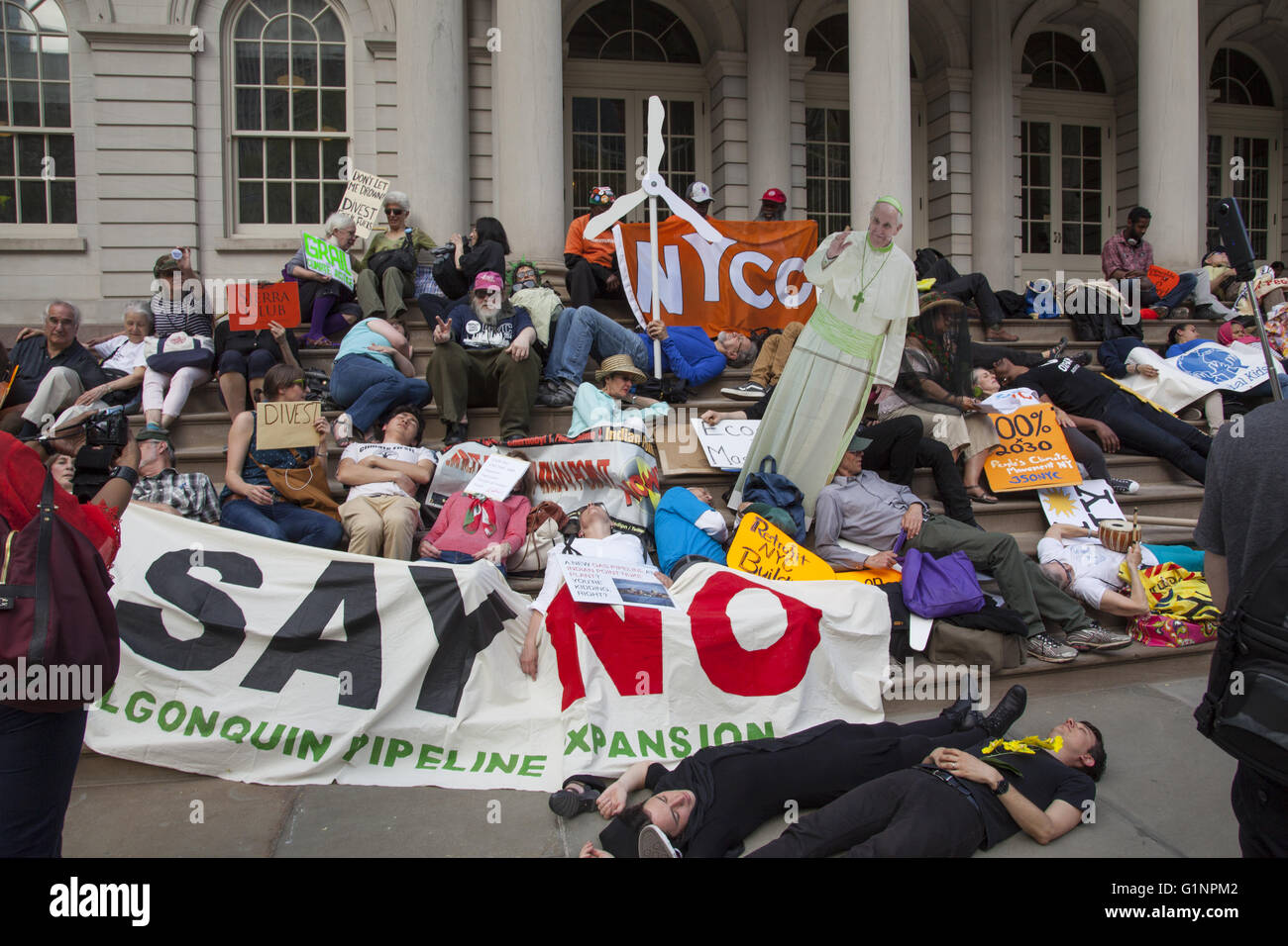 Various environmental groups including the Sierra Club joined forces at city hall in NYC to remind Mayor de Blasio to push forward with his promise to switch the city over to renewable energy sources. The ended the press conference with a die-in for dramatic effect. Stock Photo