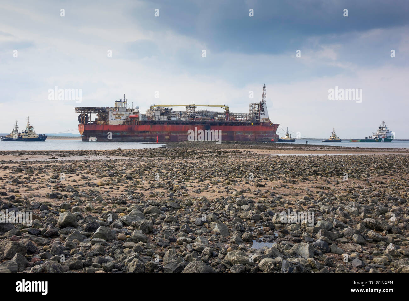 Teesport Redcar Cleveland UK  17 May 2016 18:00. A Floating Oil and Gas production vessel after 18 years life in the North Sea was laid up in Middlesbrough in August 2015.  The vessel was towed out of Teesport today by Ocean going  tug  Terasea Hawk, on route to a new job in Nigeria.  The towage was assisted by four harbour tugs.  Outside the harbour, the Tees Pilot was taken off by a pilot boat and the crew on the lifted off by helicopter. Credit:  Peter Jordan NE/Alamy Live News Stock Photo