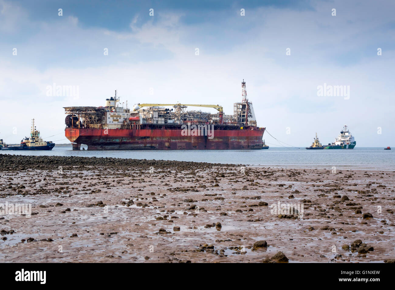 Teesport Redcar Cleveland UK  17 May 2016 18:00. A Floating Oil and Gas production vessel after 18 years life in the North Sea was laid up in Middlesbrough in August 2015.  The vessel was towed out of Teesport today by Ocean going  tug  Terasea Hawk, on route to a new job in Nigeria.  The towage was assisted by four harbour tugs.  Outside the harbour, the Tees Pilot was taken off by a pilot boat and the crew on the lifted off by helicopter. Credit:  Peter Jordan NE/Alamy Live News Stock Photo