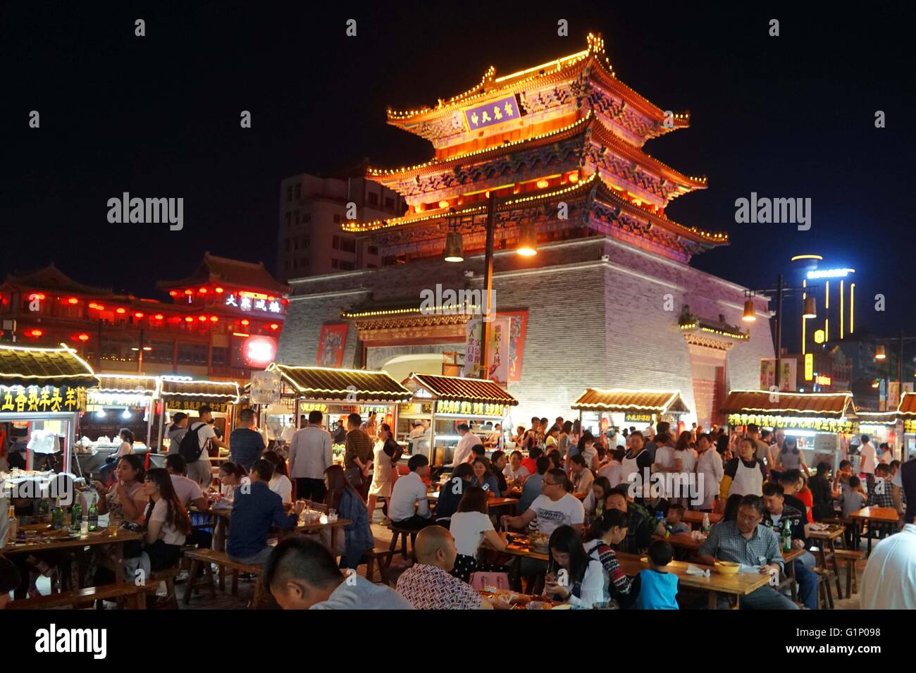 (160518) -- KAIFENG, May 18, 2016 (Xinhua) -- Photo taken on May 17, 2016 shows the scene of a night market next to a drum-tower in Kaifeng, central China's Henan Province. Kaifeng has a long history of its famous night market where a wide range of food specialities such as five-spice bread, steaming pie and dumplings are on sale. In the evening, Kaifeng's streets turn into restaurants while hundreds of vendors open their stands and begin selling food for people from the nearby cities, as the atmosphere is very appealing. Kaifeng is historically known as Daliang, Bianliang, Bianjing, Dongjing  Stock Photo