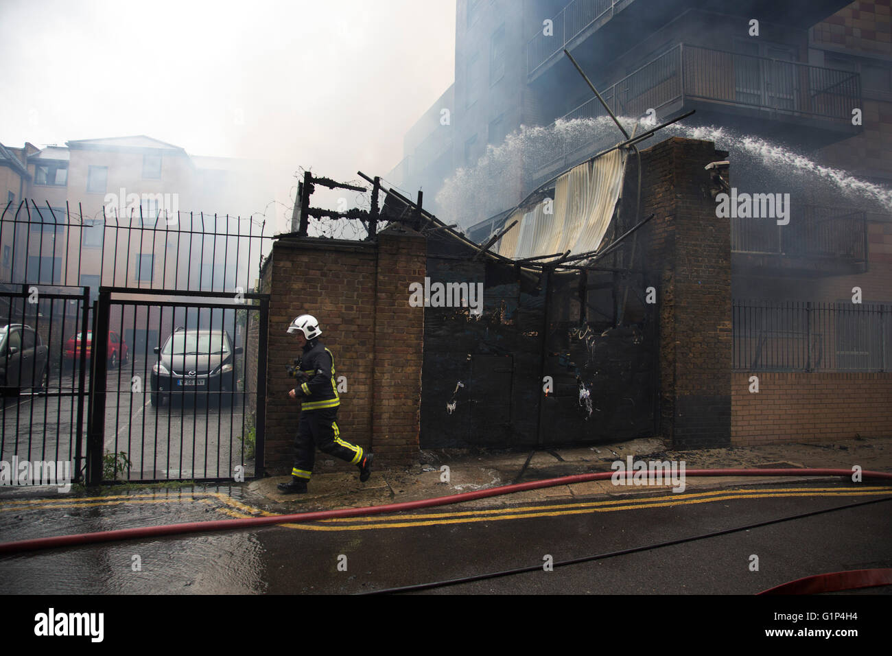 Fire fighters tackle a fire in a block of flats in Brodlove Lane in Wapping, London, United Kingdom. According to sources the fire was possibly due to gas cylinders which were in a builders yard at the base of the building. A local resident said that there were often fires in this area, though he didn't know what was the cause. Stock Photo