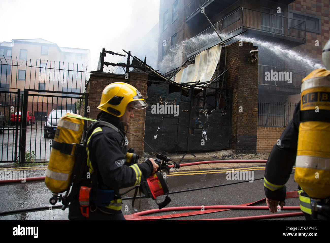 Fire fighters tackle a fire in a block of flats in Brodlove Lane in Wapping, London, United Kingdom. According to sources the fire was possibly due to gas cylinders which were in a builders yard at the base of the building. A local resident said that there were often fires in this area, though he didn't know what was the cause. Stock Photo