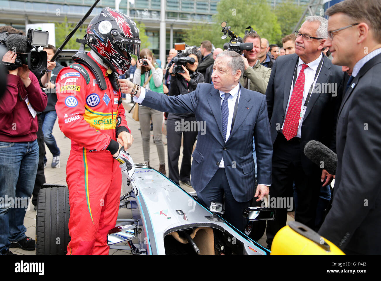 Leipzig, Germany. 18th May, 2016. Jean Todt (C-R), president of the International Automobile Federation (FIA), speaks to racing driver Daniel Abt (C-L) during the presentation of an electric Formula E racing car at the world summit of transport ministers in Leipzig, Germany, 18 May 2016. Some 1,000 participants from 60 countries are expected to attend the three-day summit held by the International Transport Forum of the Organisation for Economic Co-operation and Development (OECD). Photo: JAN WOITAS/dpa/Alamy Live News Stock Photo