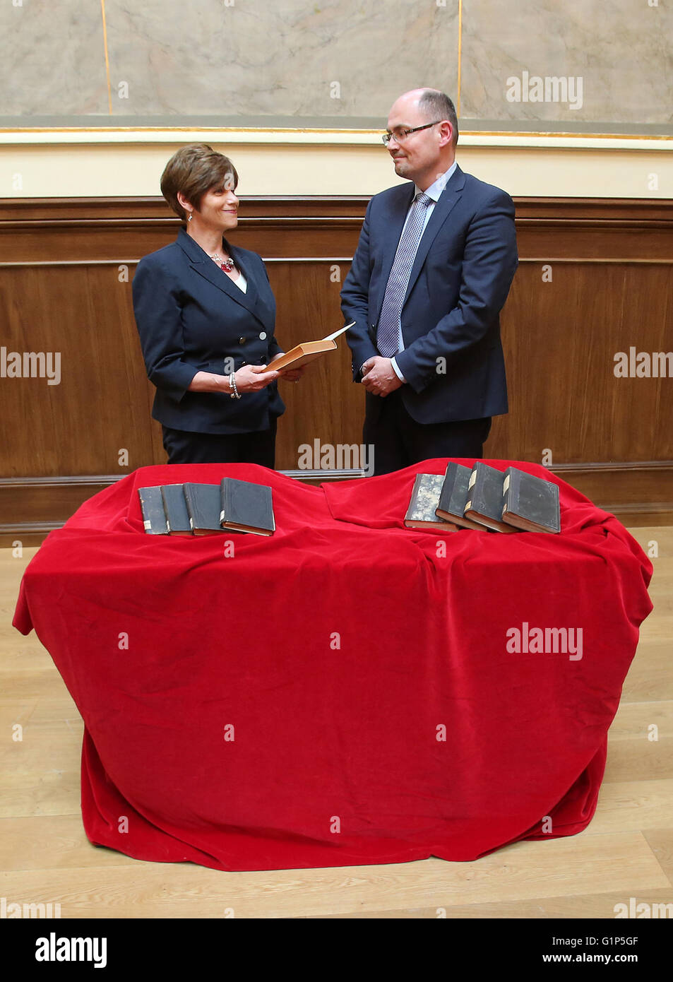 Rostock, Germany. 18th May, 2016. Library head Robert Zepf (R) hands over stolen books from the inventory of the Rostock university library to heiress Audrey Goodman of the USA during a restitution ceremony in Rostock, Germany, 18 May 2016. A project supported by the German Lost Art Foundation was launched to locate the German Nazi plunder goods. The nine books were wrongfully seized by the Nazis and subsequently exchanged or donated to the Rostock university library. Photo: BERND WUESTNECK/dpa/Alamy Live News Stock Photo