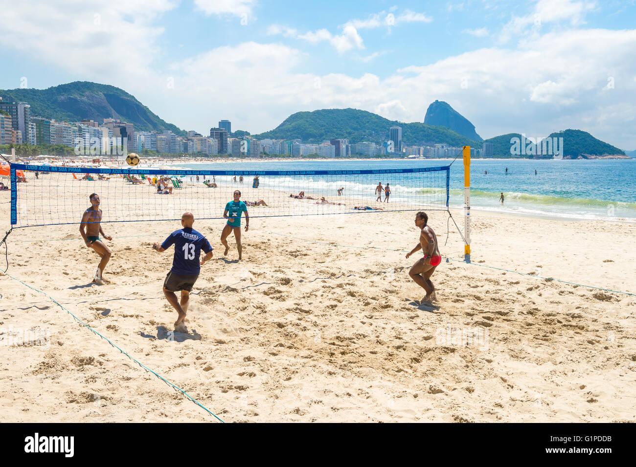RIO DE JANEIRO - MARCH 15, 2016: Brazilian men play a game of futevolei (footvolley, a sport combining football and volleyball Stock Photo