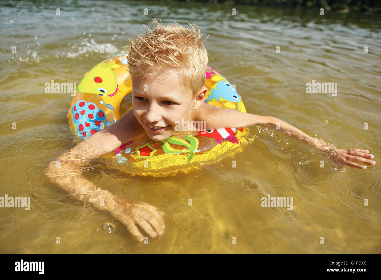 boy with floating ring bathing and splashing in the lake Stock Photo ...