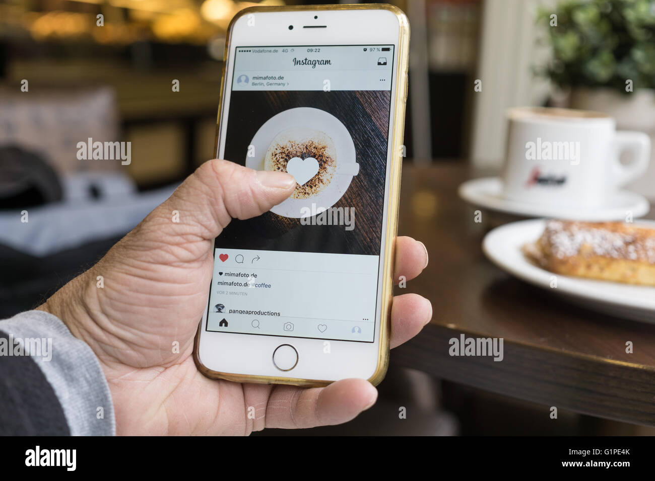 BERLIN, GERMANY - MAY 17, 2016: Man using the newly designed Instagram app on his iPhone 6 Plus. Stock Photo
