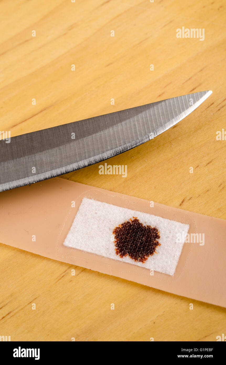 Kitchen knife and band aid, domestic accident concept Stock Photo