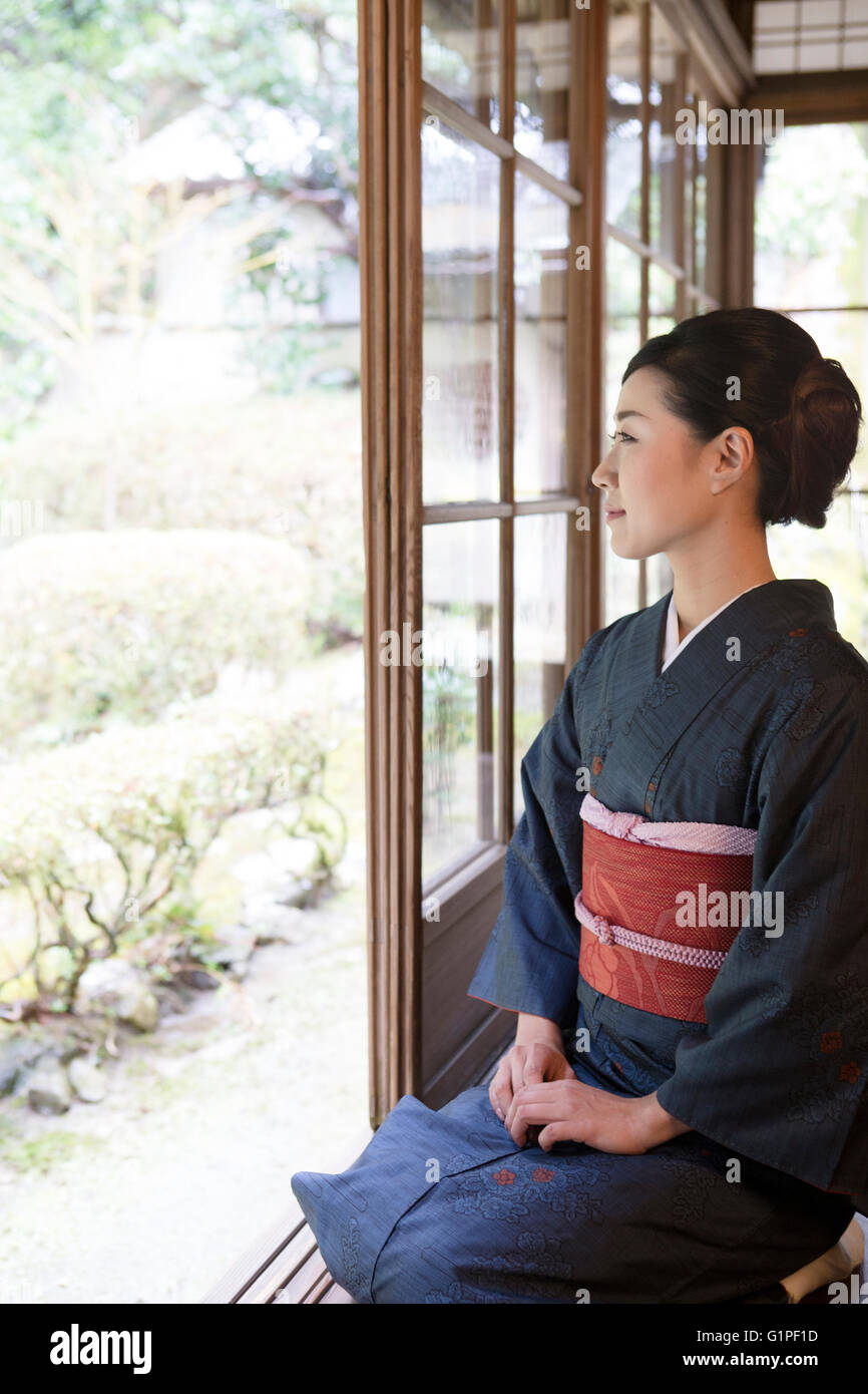Young Japanese woman in kimono sitting on wooden porch Stock Photo - Alamy