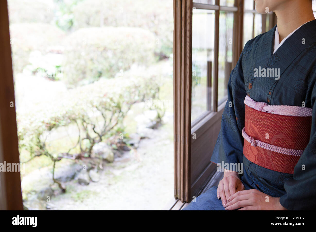 Young Japanese woman in kimono sitting on wooden porch Stock Photo - Alamy