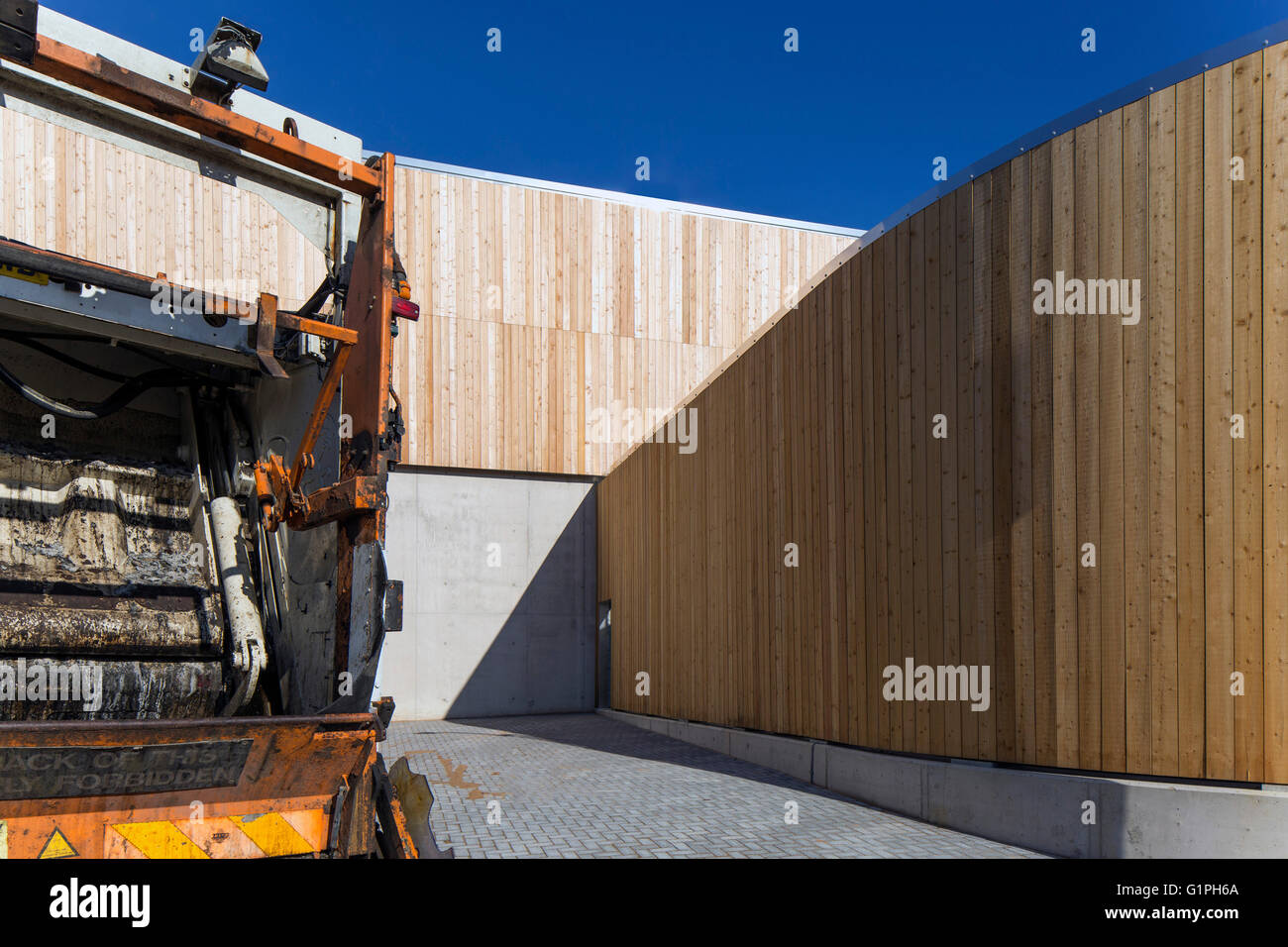 Curved timber cladding of recycling halls and arrival of garbage truck. Bridport Recycling Centre, Bridport, United Kingdom. Architect: Mitchell Eley Gould, 2015. Stock Photo
