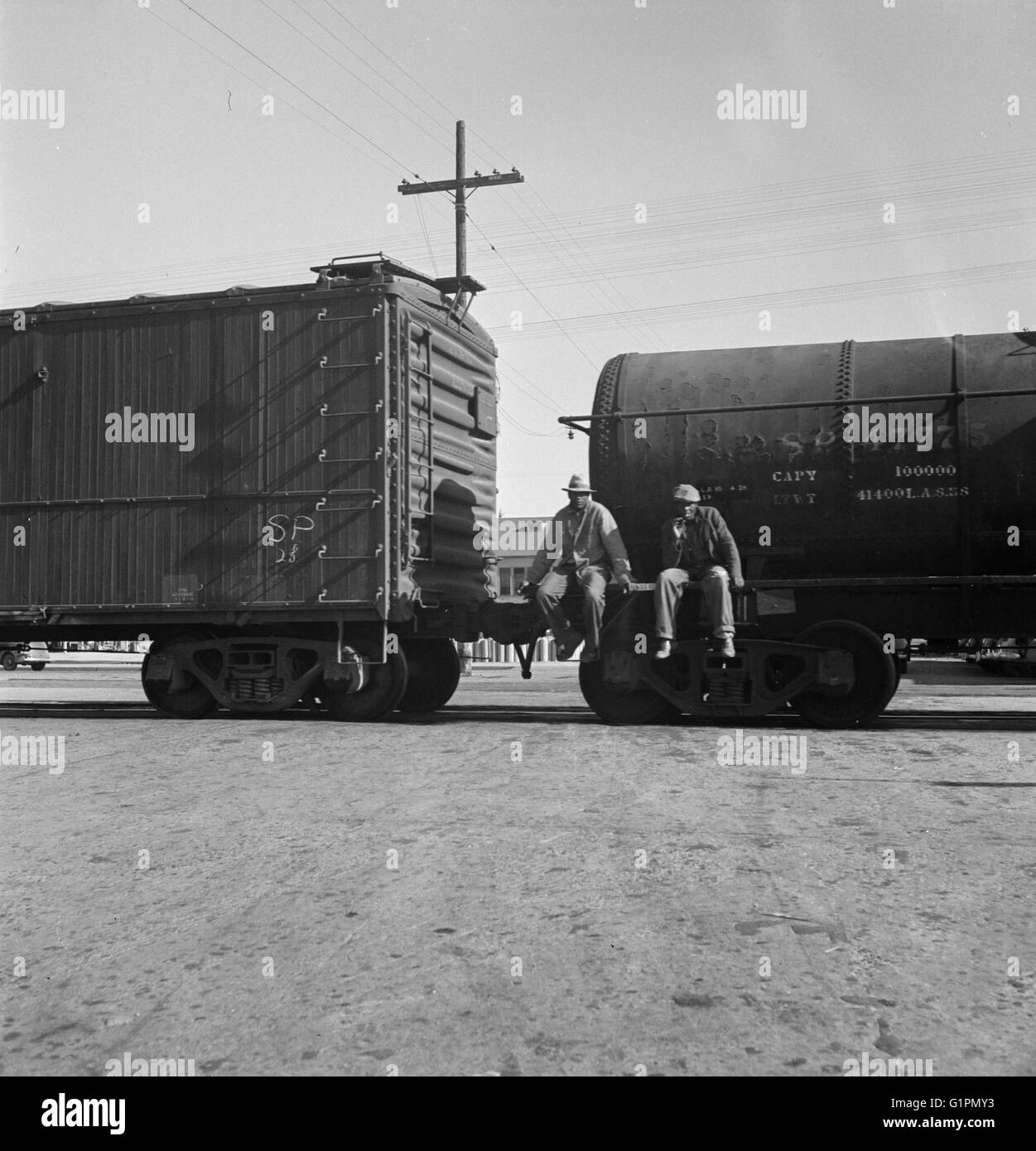 RAILROAD, 1937.  Itinerant men riding outside a train hauling oil tanks in Kingsbury, California.  Photograph by Dorothea Lange, 1938. Stock Photo