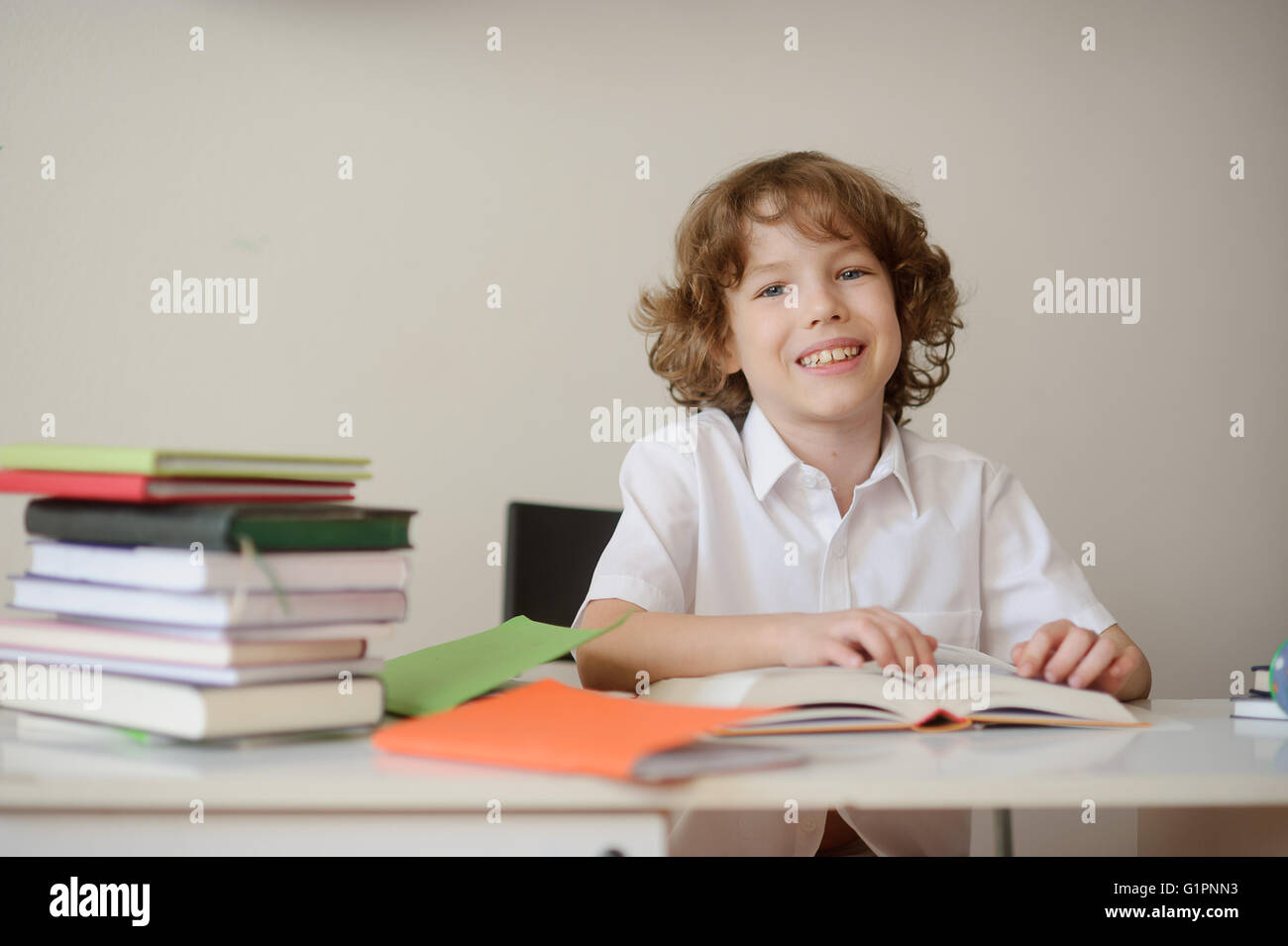 Smiling boy sitting at a school desk Stock Photo - Alamy