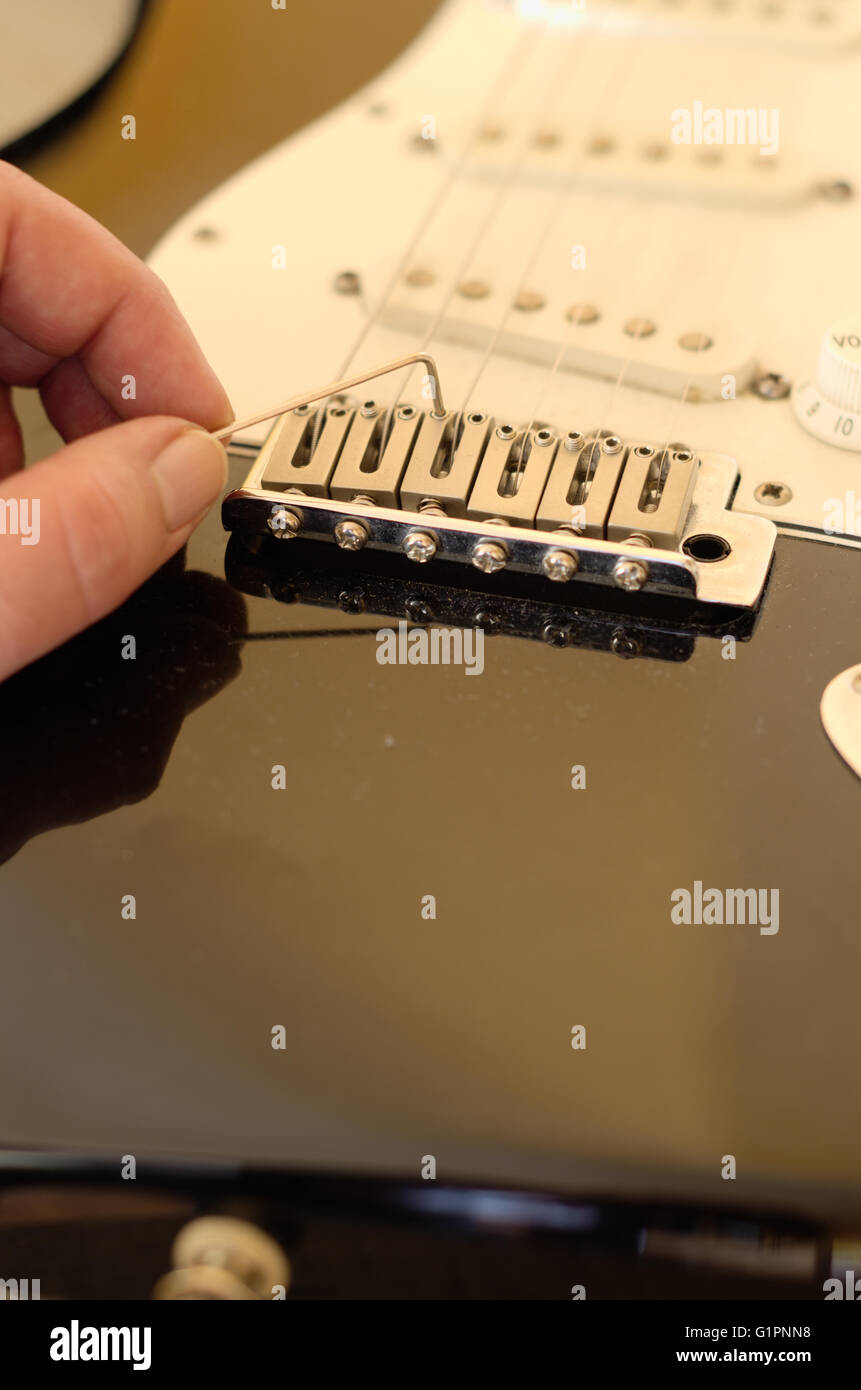 Hand close-up tuning a vintage electric guitar Stock Photo