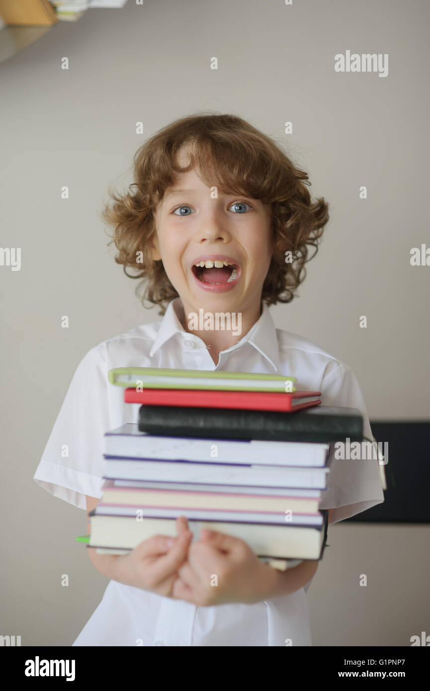 The boy holds a stack of books Stock Photo - Alamy