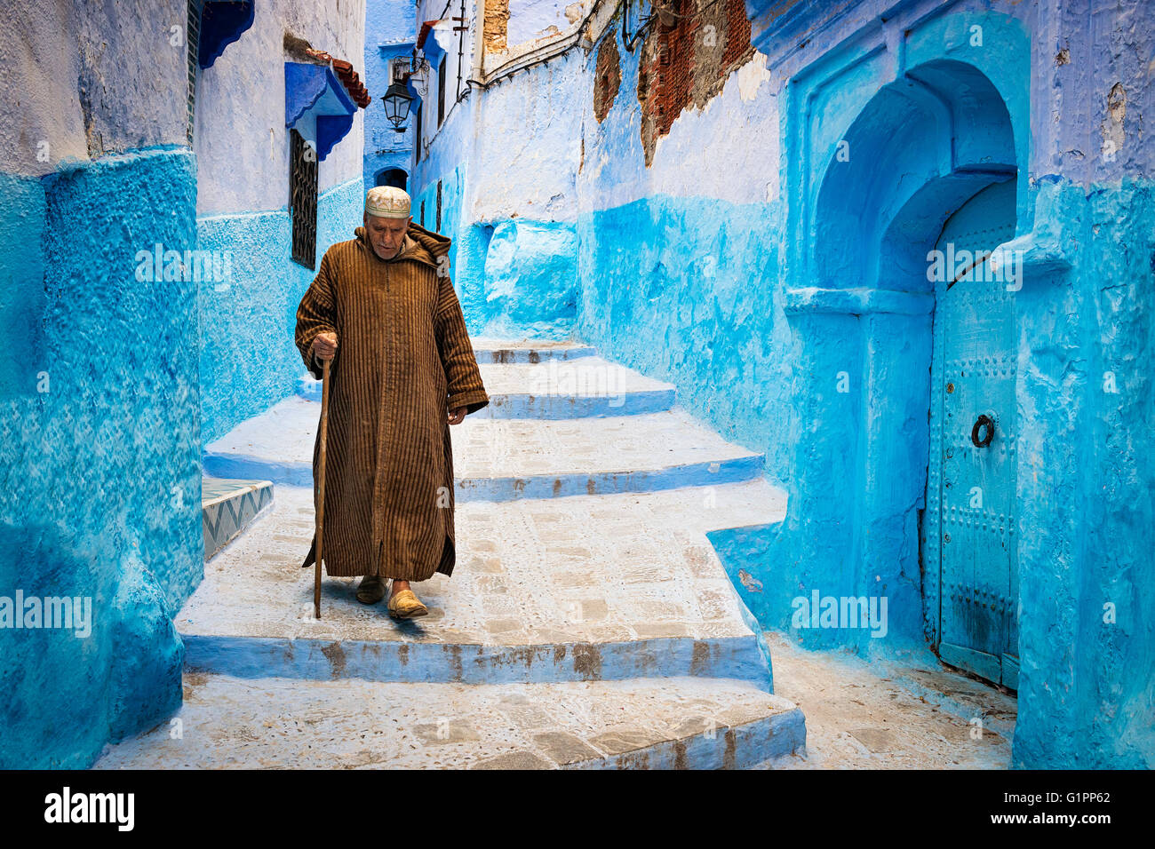 Chefchaouen, Morocco - April 10, 2016: An old man walking in a street of the town of Chefchaouen in Morocco. Stock Photo