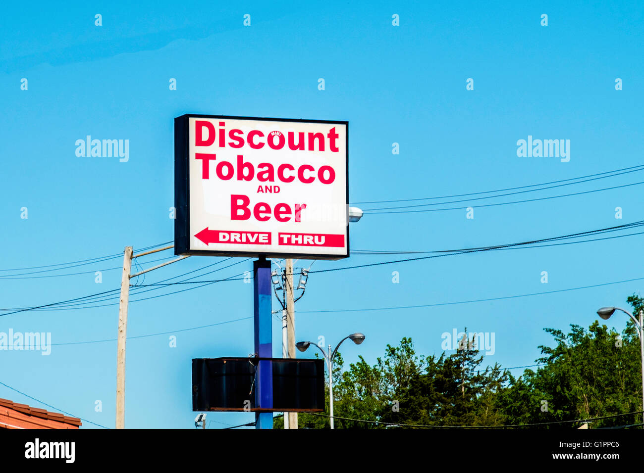 A pole sign advertising discount tobacco and beer, with drive thru
