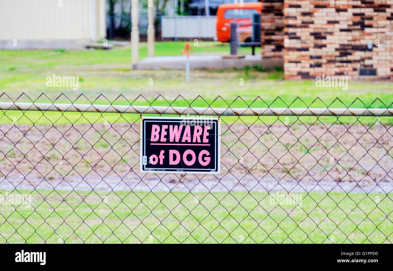 Beware of Dog sign hanging on a cyclone fence around a home in Oklahoma, USA. Stock Photo
