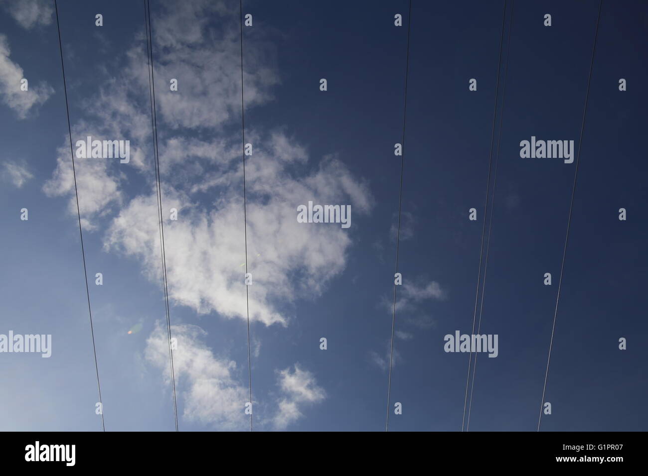 Cables on high voltage power line on a dark blue sky with cloudscape ...