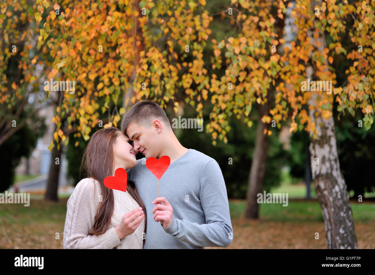 loving couple with red heart in the autumn park. love concept Stock Photo