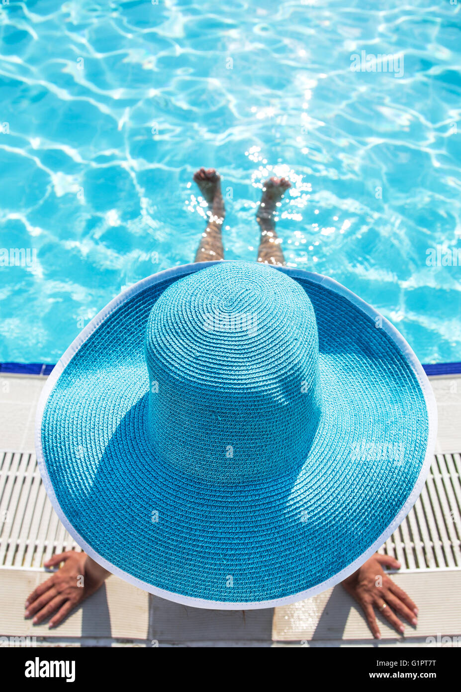 Woman sitting on the edge of swimming pool Stock Photo - Alamy