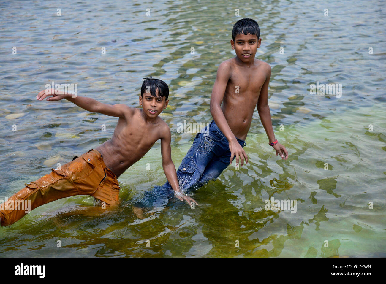 Bangladeshi children bathe in a Sohrawardi Uddan Lake during a hot