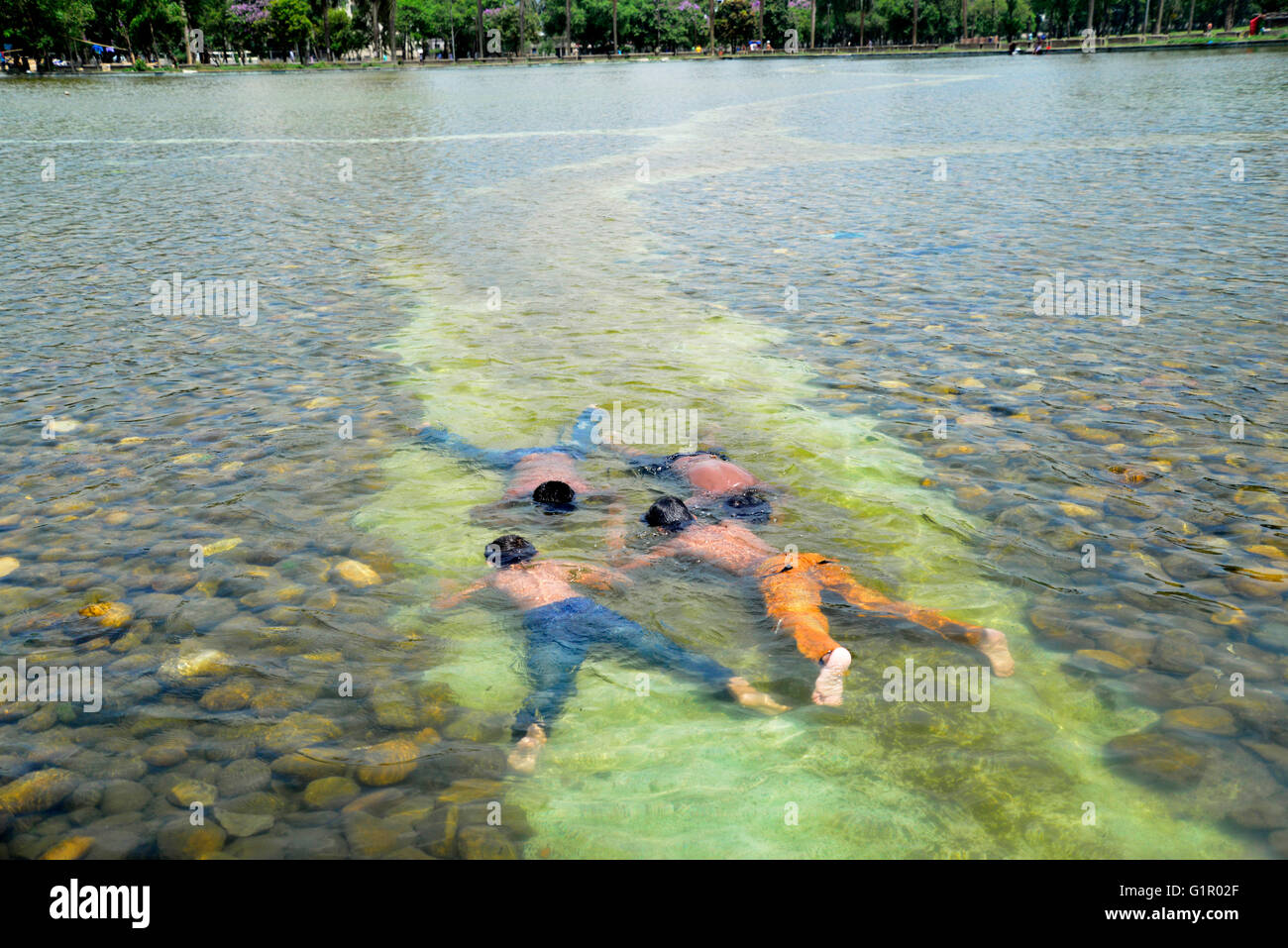 Bangladeshi children bathe in a Sohrawardi Uddan Lake during a hot