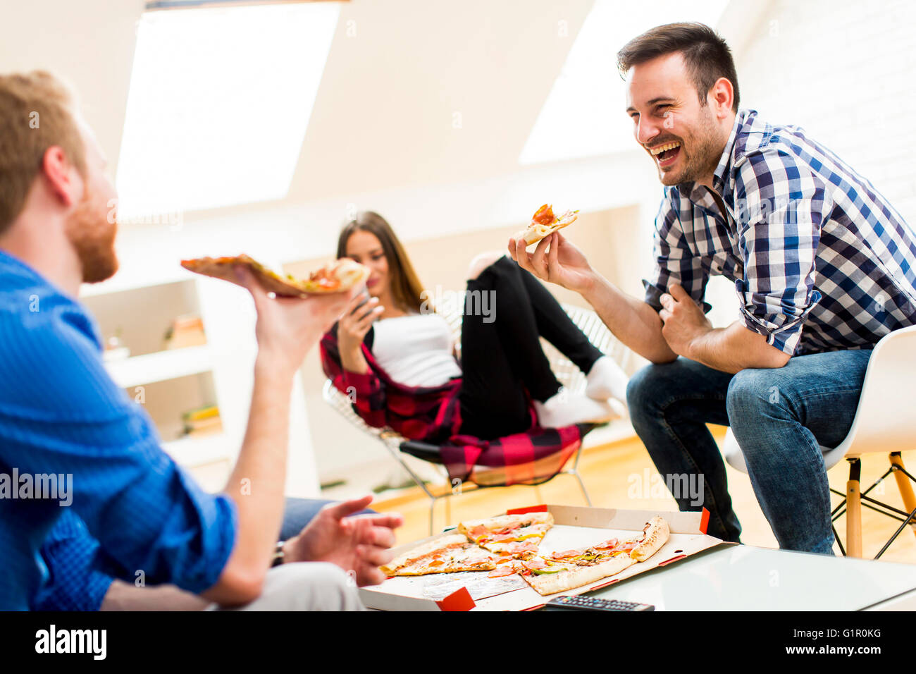 Group Of Friends Eating Pizza Together At Home Stock Photo, Picture and  Royalty Free Image. Image 56950664.