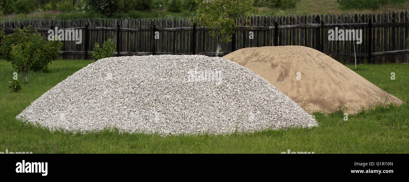 Heaps of sand and broken stone on the grass photo Stock Photo