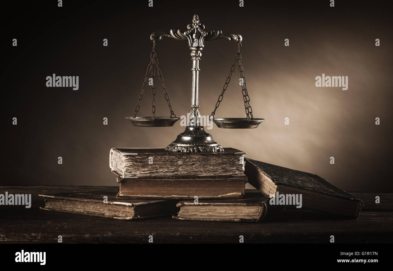 Old silver scale and hardcover books on a wooden table, justice and knowledge concept Stock Photo